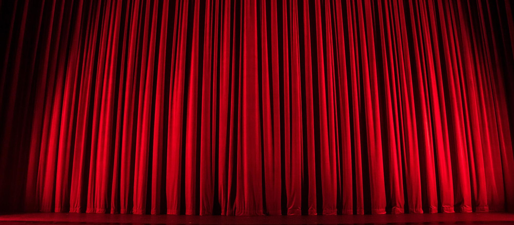 Foto eines roten Theatervorhangs.